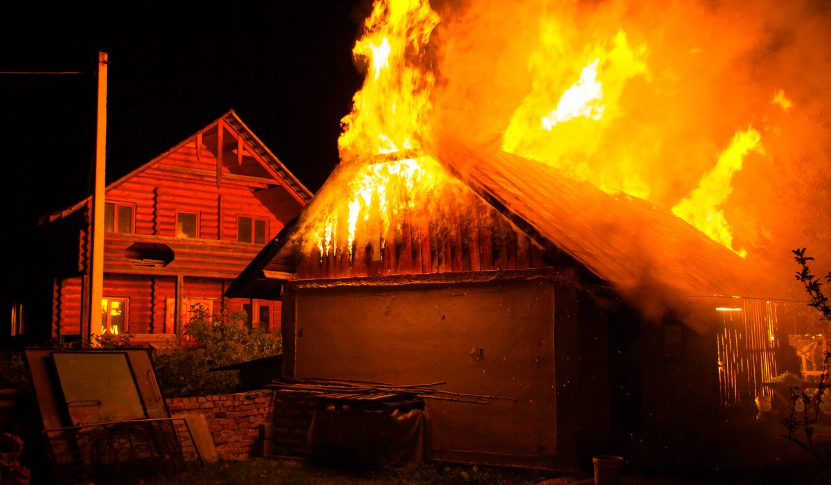 Wooden house or barn burning on fire at night
